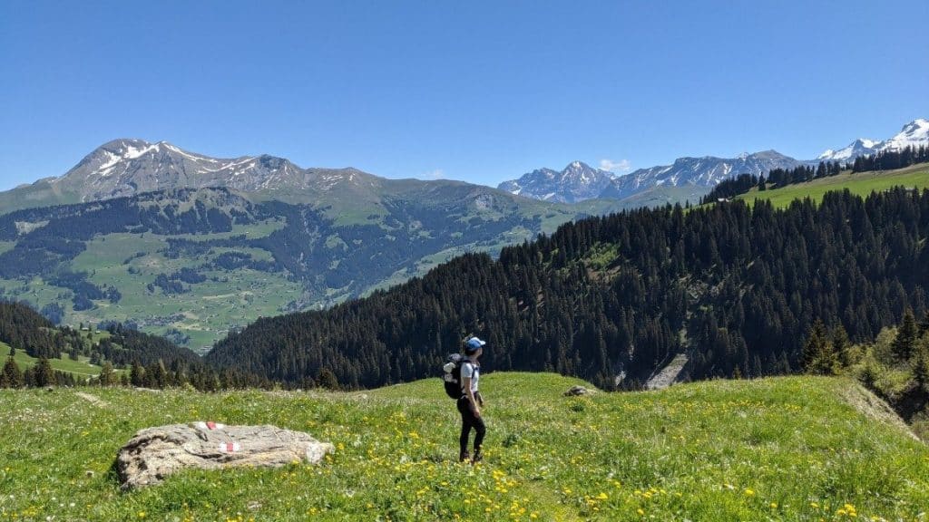 Solène wandert hinauf zum Trüttlisbergpass. Im Hintergrund Blick auf die Schweizer Alpen.
