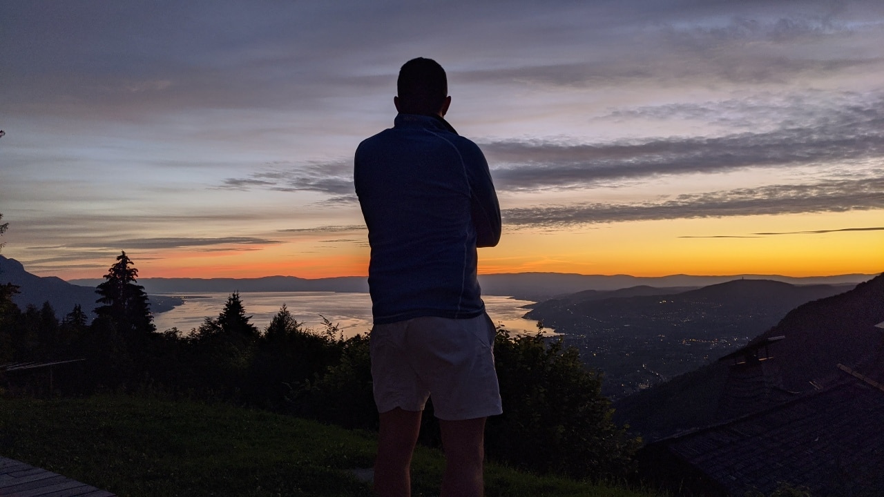 Matthias auf der Terasse des Restaurants Coucou über Montreux. Im Hintergrund ein Sonnenuntergang über dem Genfersee.