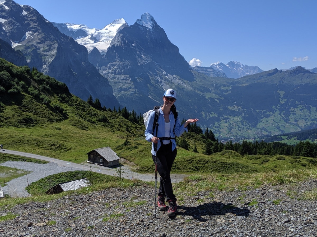 Solène standing on Grosse Scheidegg Switzerland. In the background the Bernese Alps Eiger, Mönch and Jungfrau.