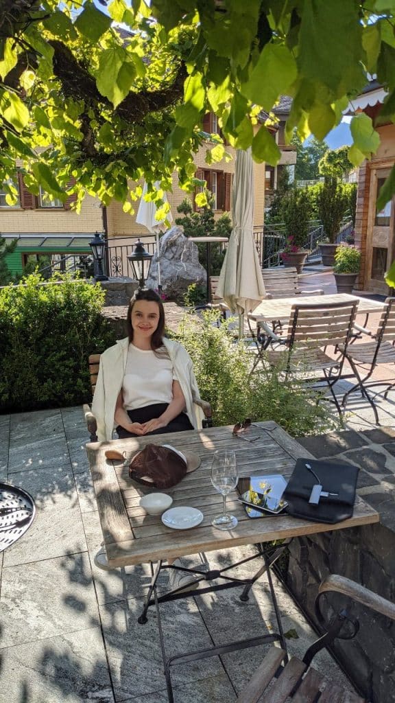 Solène sitzt am Tisch auf der Terrasse des Hotels Schönegg in Wengen, Schweiz.