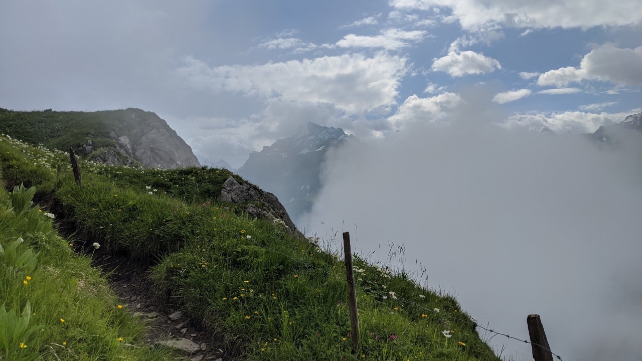 Hiking trail above the clouds on the Via Alpina from Kandersteg to Adelboden over Bunderchrine mountain pass.