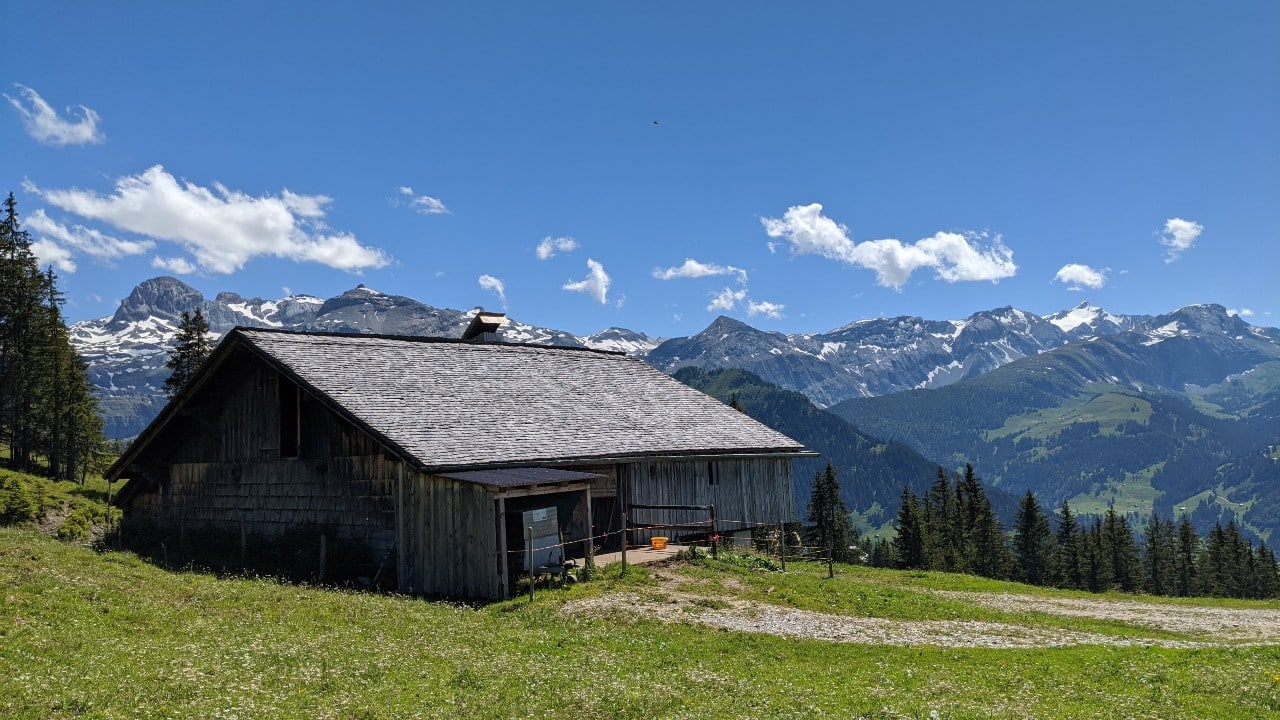 Schweizer Bauernhof an der Via Alpina. Links der Wildstrubel und Aussichten auf den Plaine Morte Gletscher.