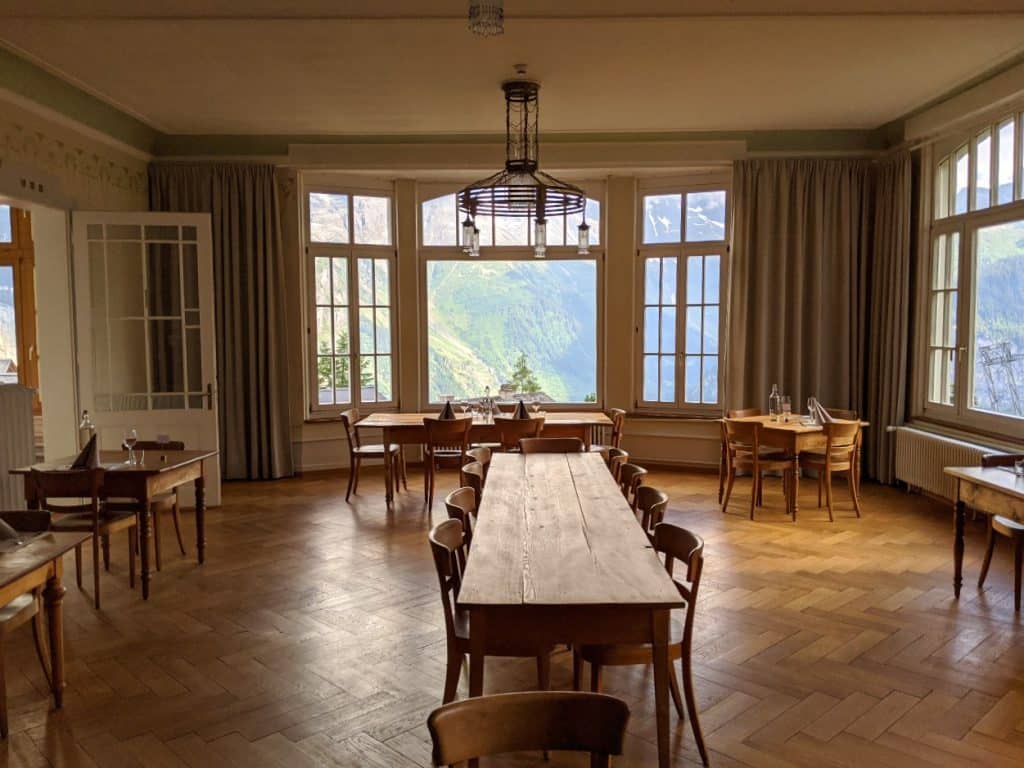 The Dining hall at hotel Regina in Mürren with views to Jungfrau massif.