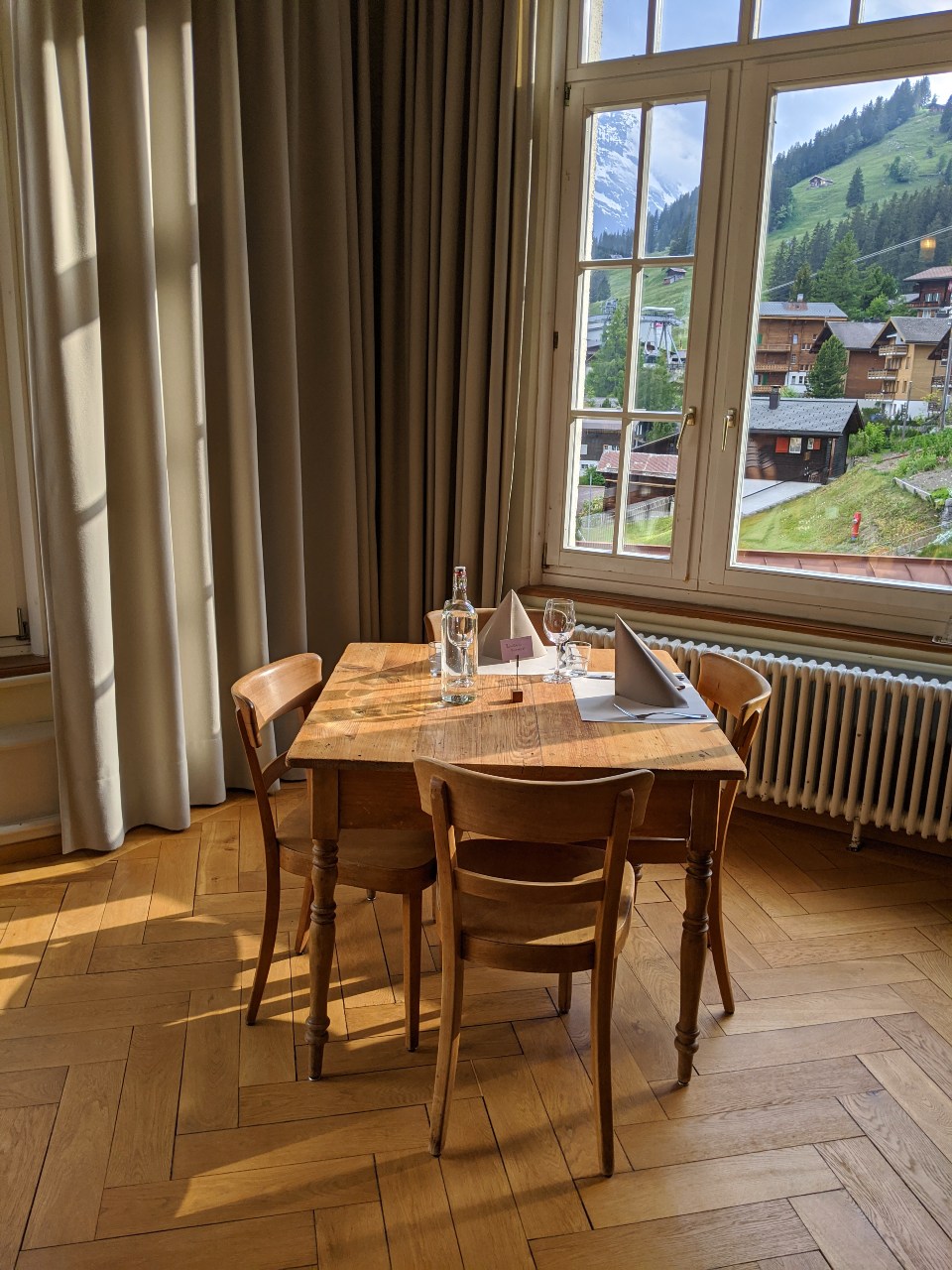 Dining table in hotel Regina in Mürren. Last sunbeams of the day caressing the wooden floor.