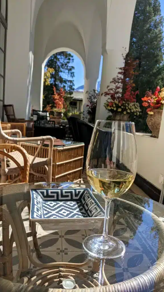 in Glas Wein, genossen auf der Veranda des Hotel Walthers im herbstlichen Sonnenschein