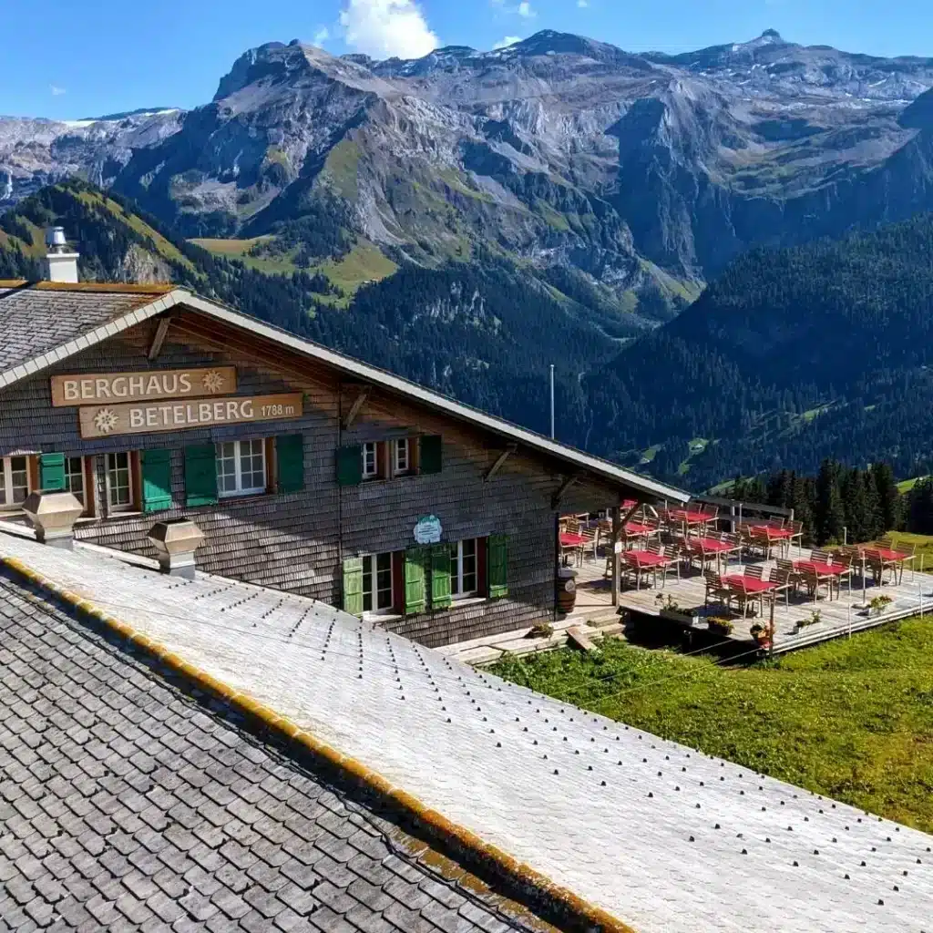 Berghaus-Betelberg, a mountain restaurant on Betelberg, Lenk, Switzerland. Behind it the Swiss Alps