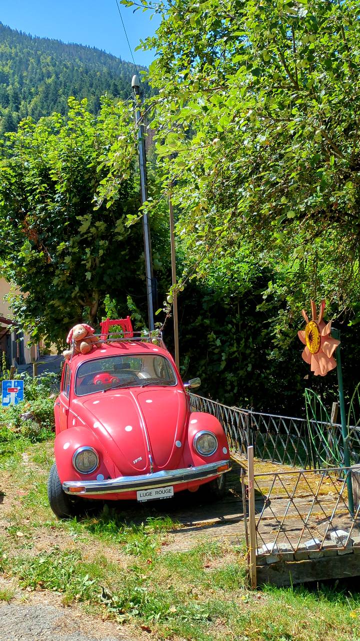 Roter VW-Käfer in Dorf Noiraigue