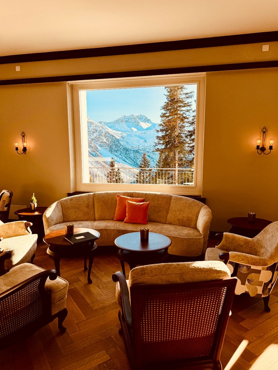 Der Salon des Hotel Prätschli in Arosa bietet grosse Fenster mit Blick auf die Bergwelt